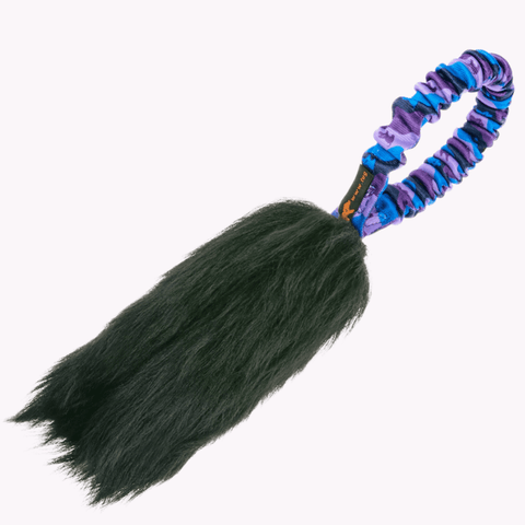 Liten draleke i lommestørrelse med sort saueskinn og lilla strikkhåndtak